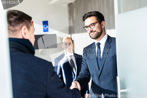 Image of Group of confident business people greeting with a handshake at business meeting in modern office or closing the deal agreement by shaking hands.