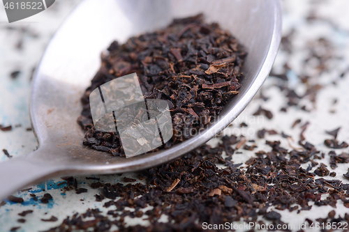 Image of Black tea in a spoon on a white background. Close up shot