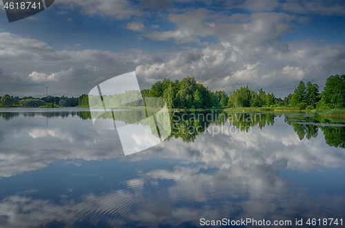 Image of Reflections in a lake with sky and trees