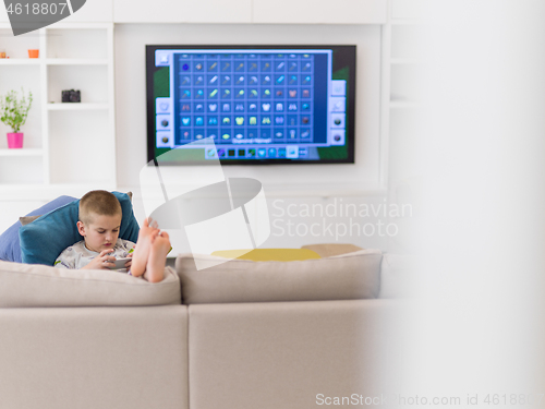 Image of little boy playing games on smartphone