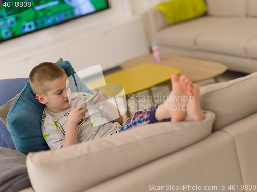 Image of little boy playing games on smartphone