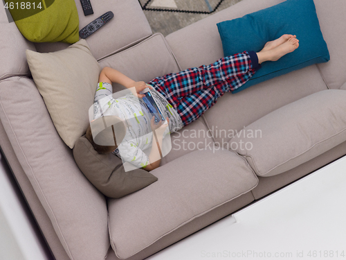 Image of top view of  little boy playing games on tablet computers