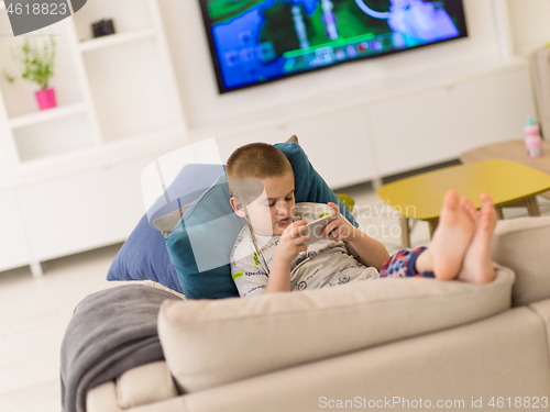 Image of little boy playing games on smartphone