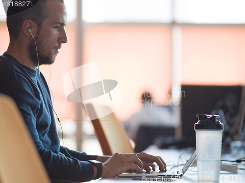 Image of businessman working using a laptop in startup office