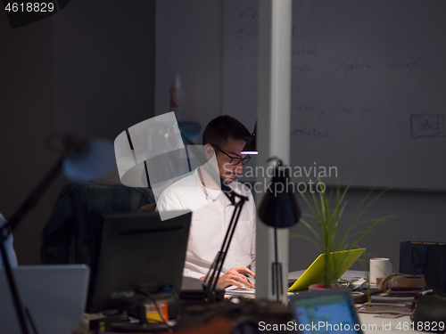 Image of businessman working using a laptop in startup office