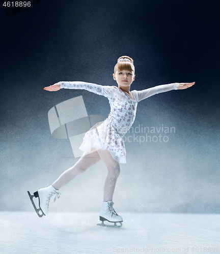 Image of Little girl figure skating at the indoor ice arena.