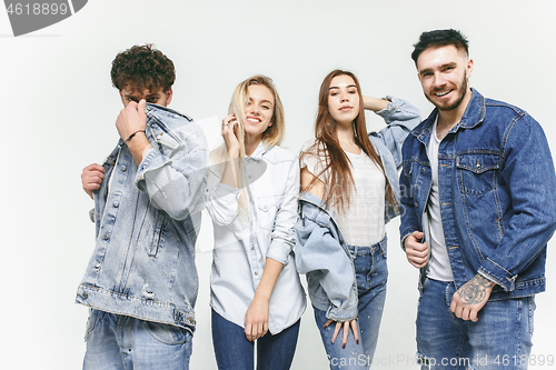 Image of Group of smiling friends in fashionable jeans