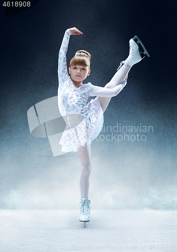 Image of Little girl figure skating at the indoor ice arena.