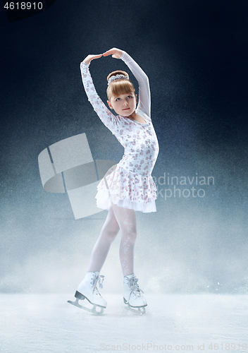 Image of Little girl figure skating at the indoor ice arena.