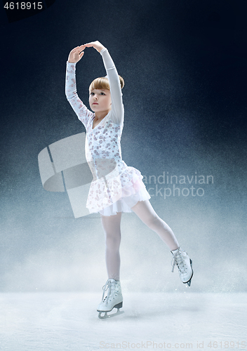 Image of Little girl figure skating at the indoor ice arena.