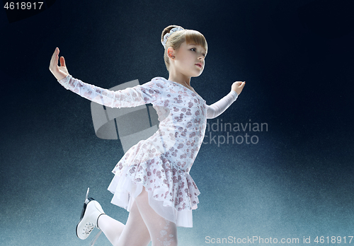 Image of Little girl figure skating at the indoor ice arena.