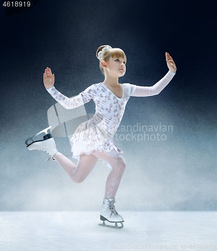 Image of Little girl figure skating at the indoor ice arena.