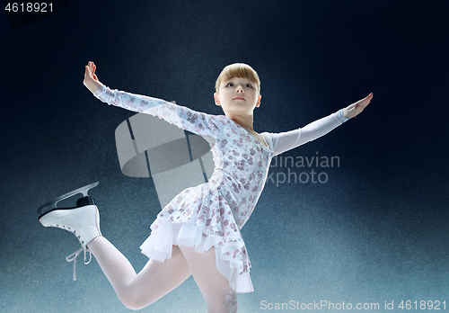 Image of Little girl figure skating at the indoor ice arena.