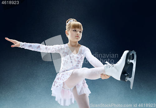 Image of Little girl figure skating at the indoor ice arena.