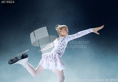 Image of Little girl figure skating at the indoor ice arena.