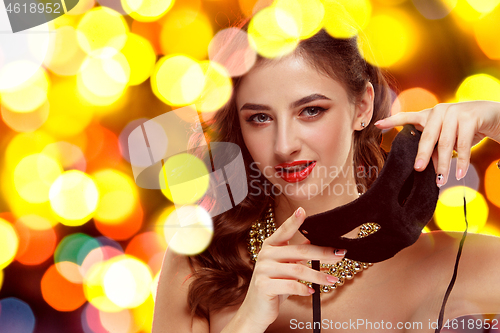 Image of Beauty model woman wearing venetian masquerade carnival mask at party