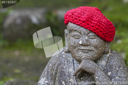 Image of Old stone statues of Buddhist monks and nuns wearing knitted and cloth hats