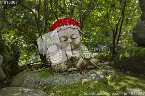 Image of Dog - symbol of japanese horoscope. Jizo stone statue wearing knitted and cloth hats.
