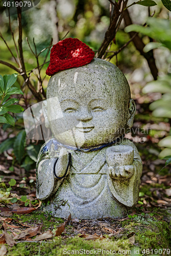 Image of Jizo stone statue wearing knitted and cloth hats.