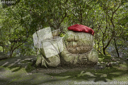 Image of Rat - symbol of japanese horoscope. Childish Jizo stone statue wearing knitted and cloth hats with zodiac animal.