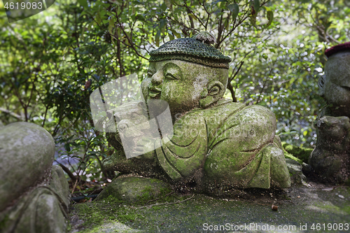 Image of Tiger - symbol of japanese horoscope. Childish Jizo stone statue wearing knitted and cloth hats with zodiac animal.