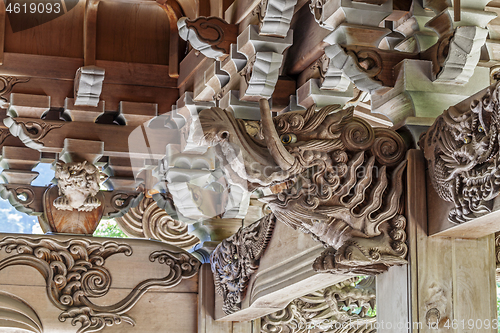 Image of Wooden carving of elephant decorates the gable of a roof over the entrance of an ancient Buddhist temple in Japan.