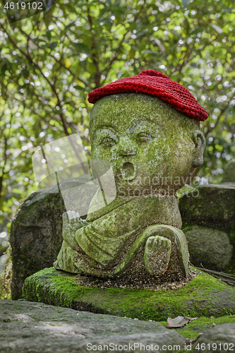 Image of Jizo stone statue wearing knitted and cloth hats.