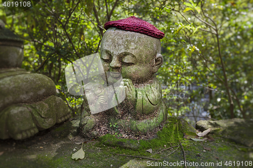 Image of Rabbit - symbol of japanese horoscope. Childish Jizo stone statue wearing knitted and cloth hats with zodiac animal.