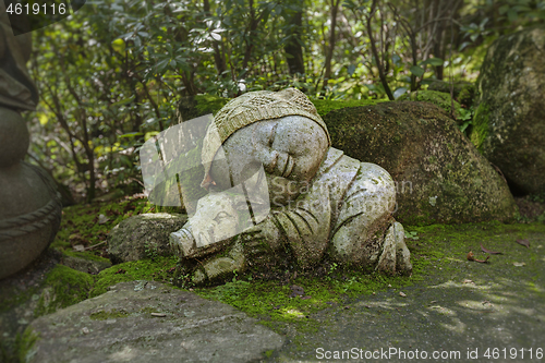 Image of Boar - symbol of japanese horoscope. Jizo stone statue wearing knitted and cloth hats.
