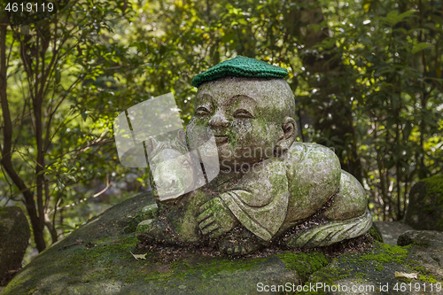 Image of Horse - symbol of japanese horoscope. Childish Jizo stone statue wearing knitted and cloth hats with zodiac animal.