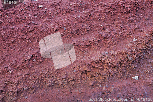 Image of A cut of soil with rocks and red soil