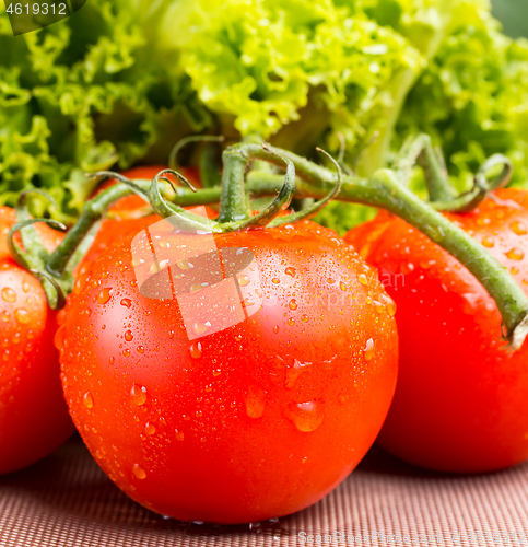 Image of Juicy red vine tomatoes with a green salad 
