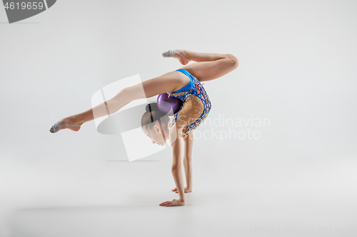 Image of The teenager girl doing gymnastics exercises isolated on white background