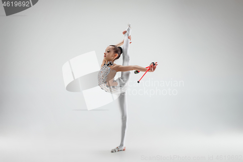 Image of The teenager girl doing gymnastics exercises isolated on white background