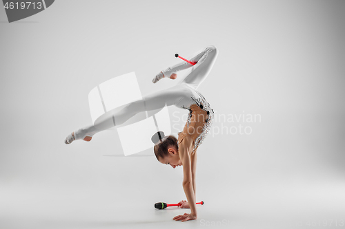 Image of The teenager girl doing gymnastics exercises isolated on white background