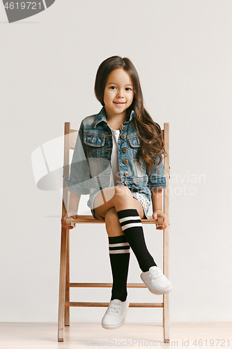 Image of Full length portrait of cute little kid in stylish jeans clothes looking at camera and smiling