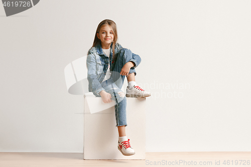 Image of Full length portrait of cute little teen in stylish jeans clothes looking at camera and smiling