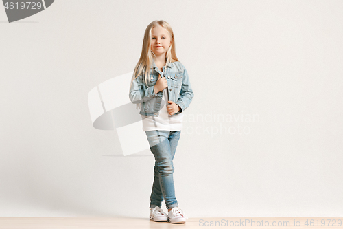 Image of Full length portrait of cute little kid in stylish jeans clothes looking at camera and smiling