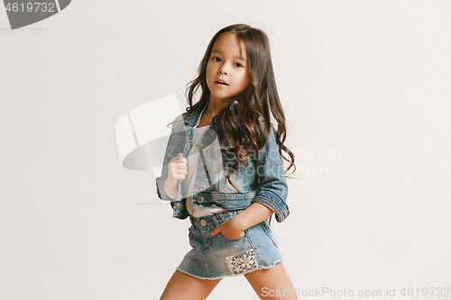 Image of Full length portrait of cute little kid in stylish jeans clothes looking at camera and smiling