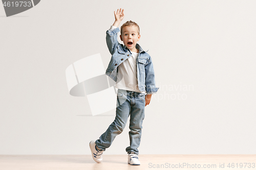 Image of The portrait of cute little boy in stylish jeans clothes looking at camera at studio