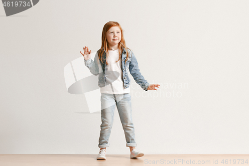 Image of Full length portrait of cute little kid in stylish jeans clothes looking at camera and smiling