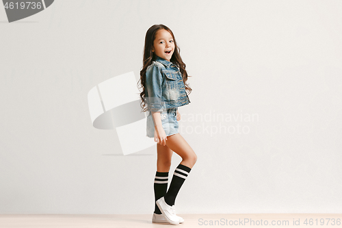 Image of Full length portrait of cute little kid in stylish jeans clothes looking at camera and smiling