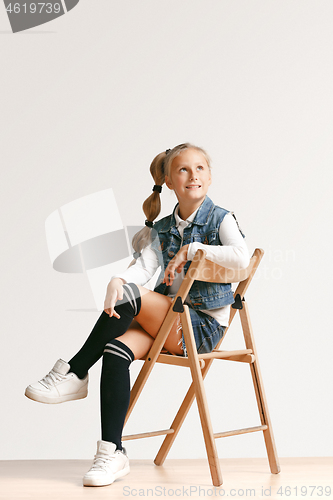 Image of Full length portrait of cute little teen in stylish jeans clothes looking at camera and smiling