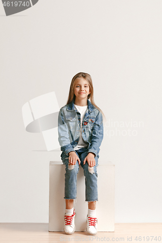 Image of Full length portrait of cute little teen in stylish jeans clothes looking at camera and smiling