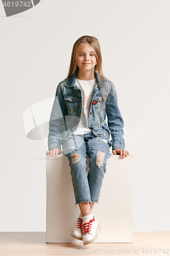 Image of Full length portrait of cute little teen in stylish jeans clothes looking at camera and smiling