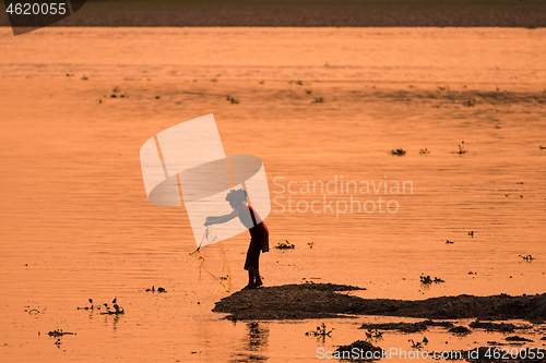 Image of Asian Woman fishing in the river, silhouette at sunset