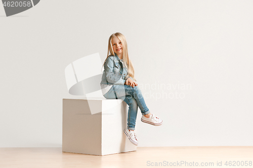 Image of The portrait of cute little kid in stylish jeans clothes looking at camera and smiling