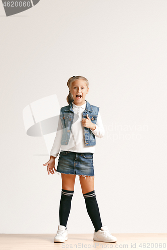 Image of Full length portrait of cute little teen in stylish jeans clothes looking at camera and smiling