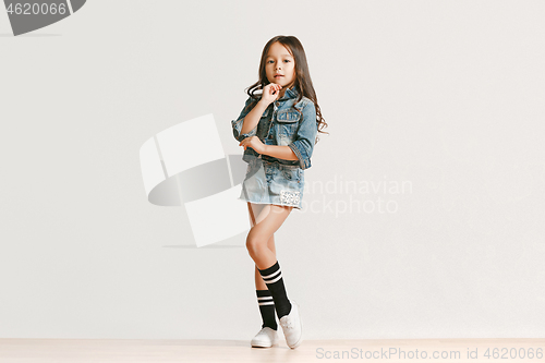 Image of Full length portrait of cute little kid in stylish jeans clothes looking at camera and smiling
