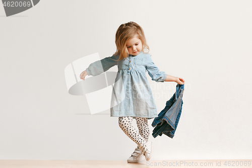 Image of Full length portrait of cute little kid in stylish jeans clothes looking at camera and smiling